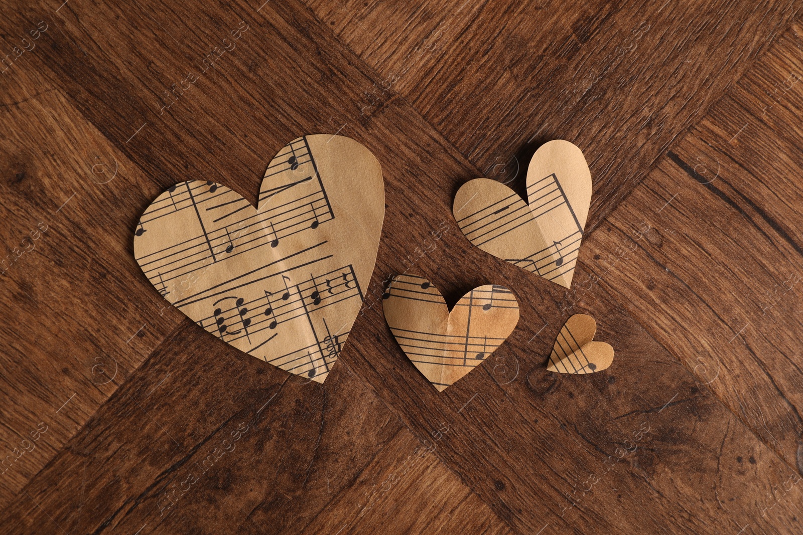 Photo of Paper hearts with notes on wooden table, flat lay