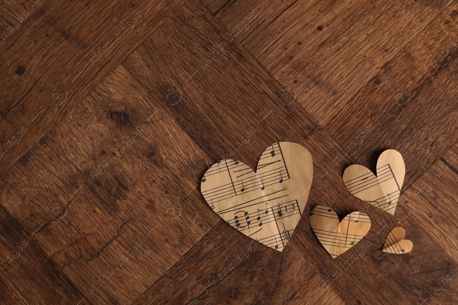 Photo of Paper hearts with notes on wooden table, flat lay. Space for text