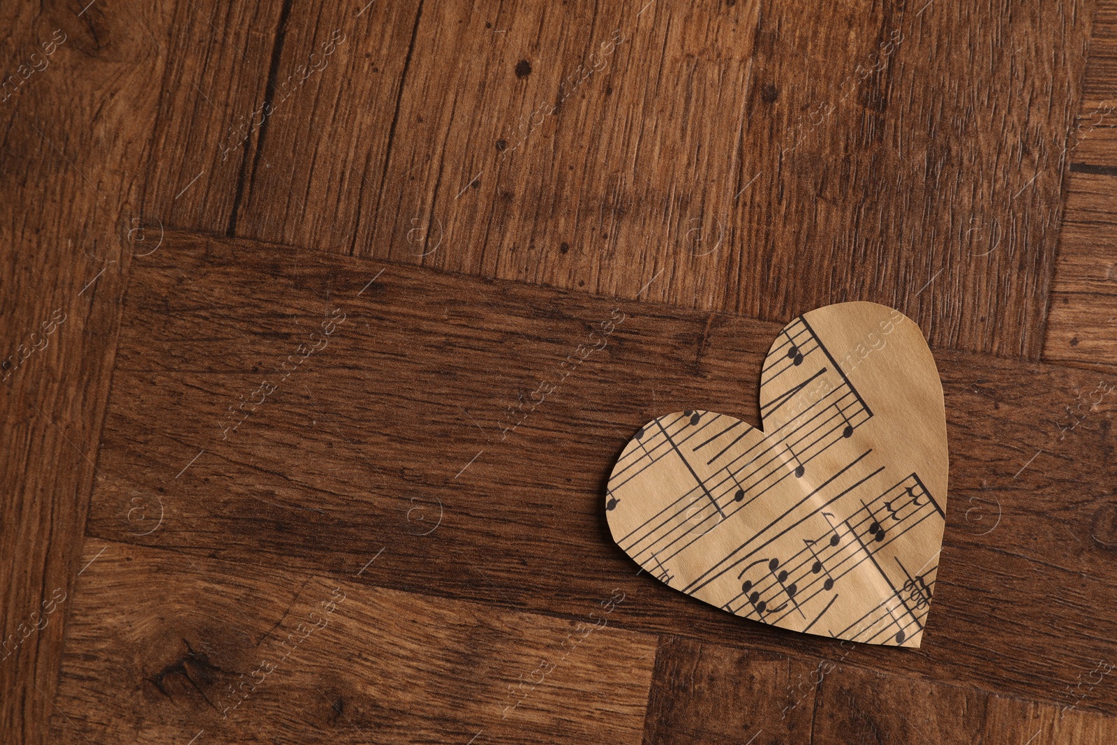 Photo of Paper heart with notes on wooden table, top view. Space for text