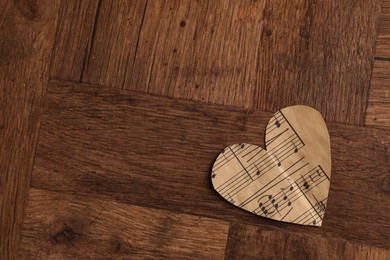 Photo of Paper heart with notes on wooden table, top view. Space for text