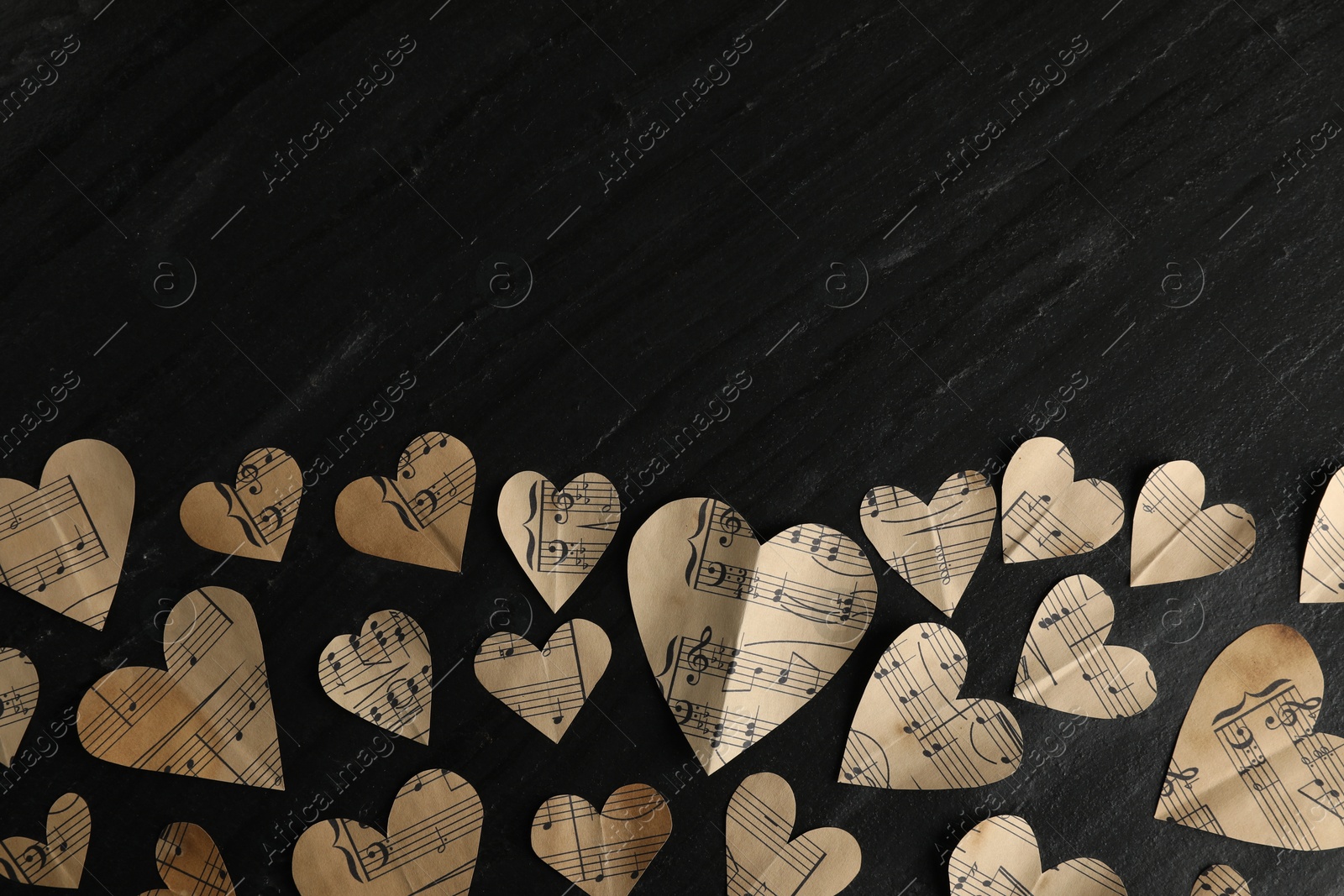 Photo of Paper hearts with notes on black table, flat lay. Space for text