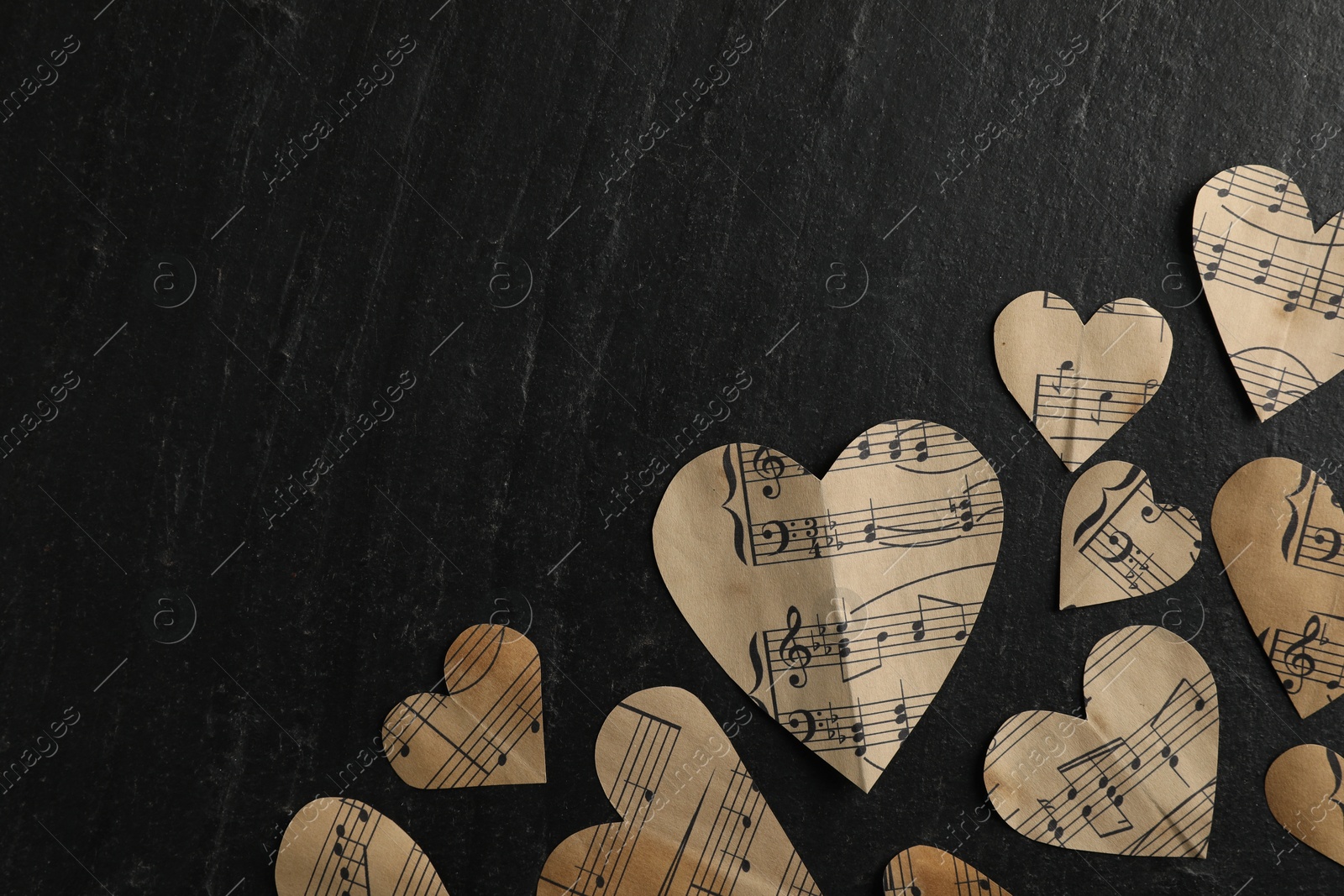 Photo of Paper hearts with notes on black table, flat lay. Space for text