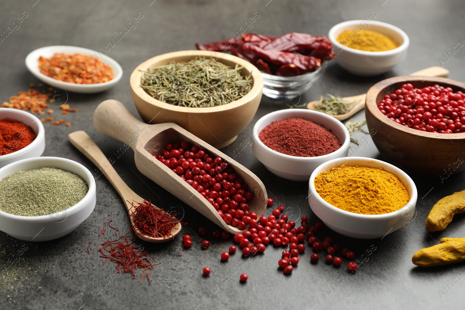 Photo of Different aromatic spices on grey table, closeup