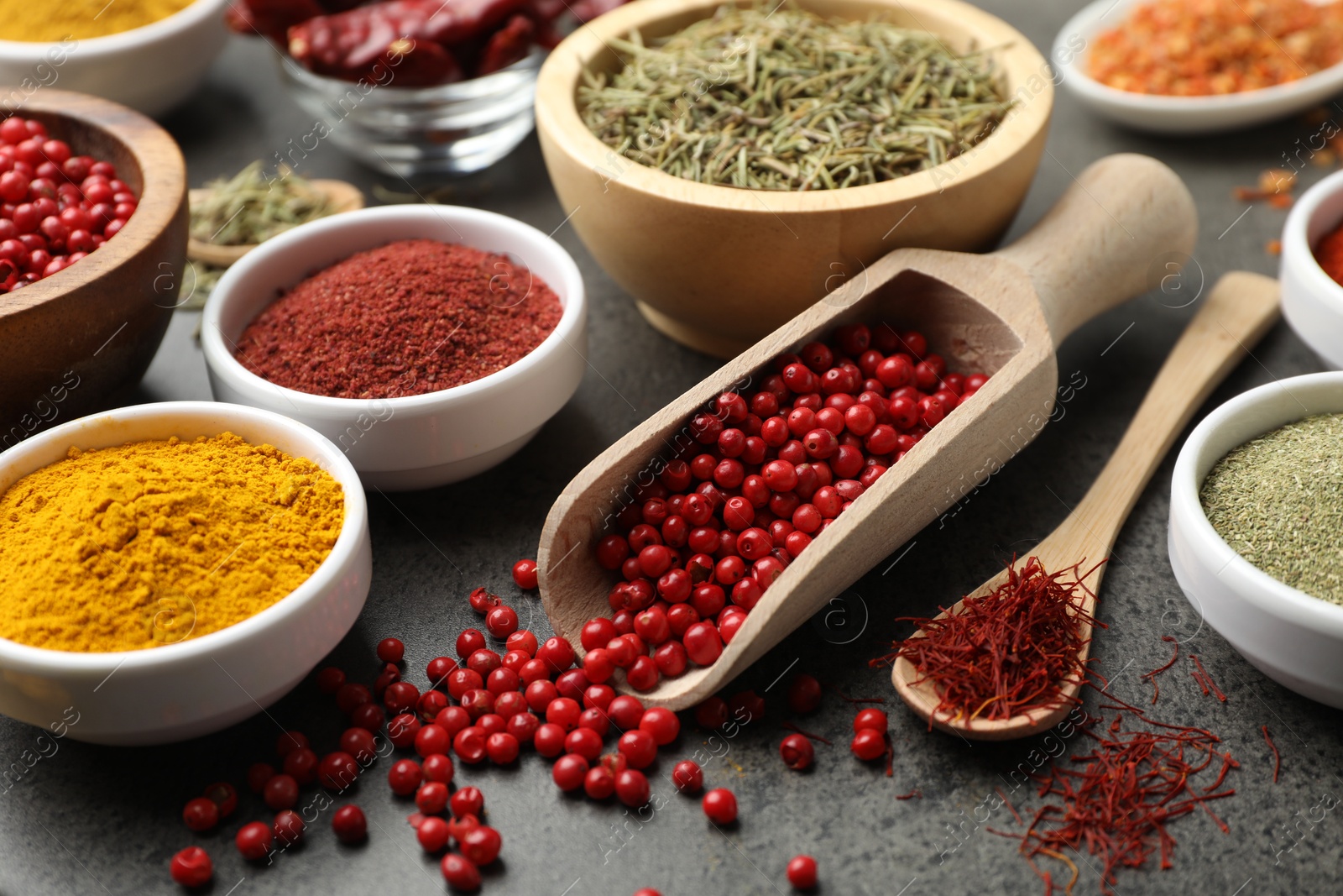 Photo of Different aromatic spices on grey table, closeup