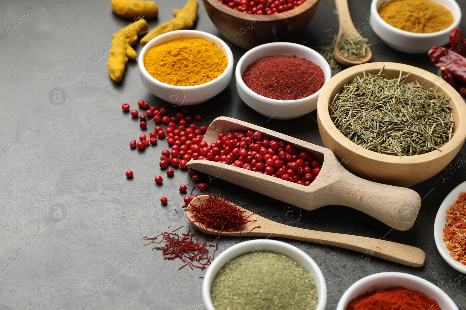 Photo of Different aromatic spices on grey table, closeup