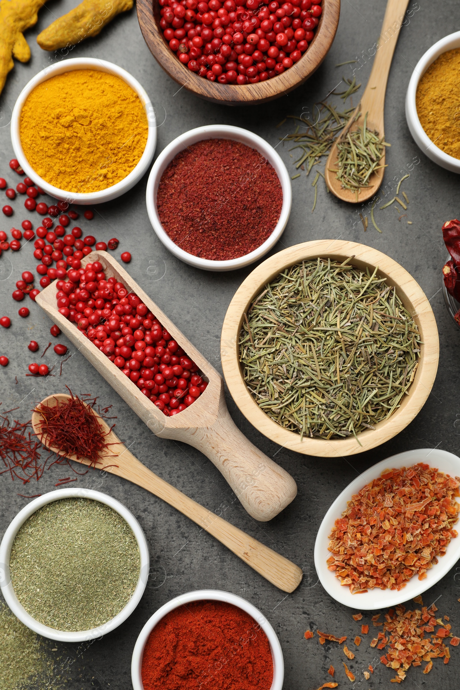 Photo of Different aromatic spices on grey table, flat lay