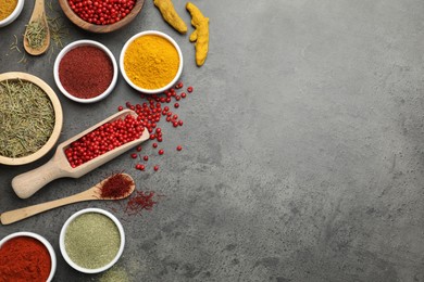 Photo of Different aromatic spices on grey table, flat lay. Space for text