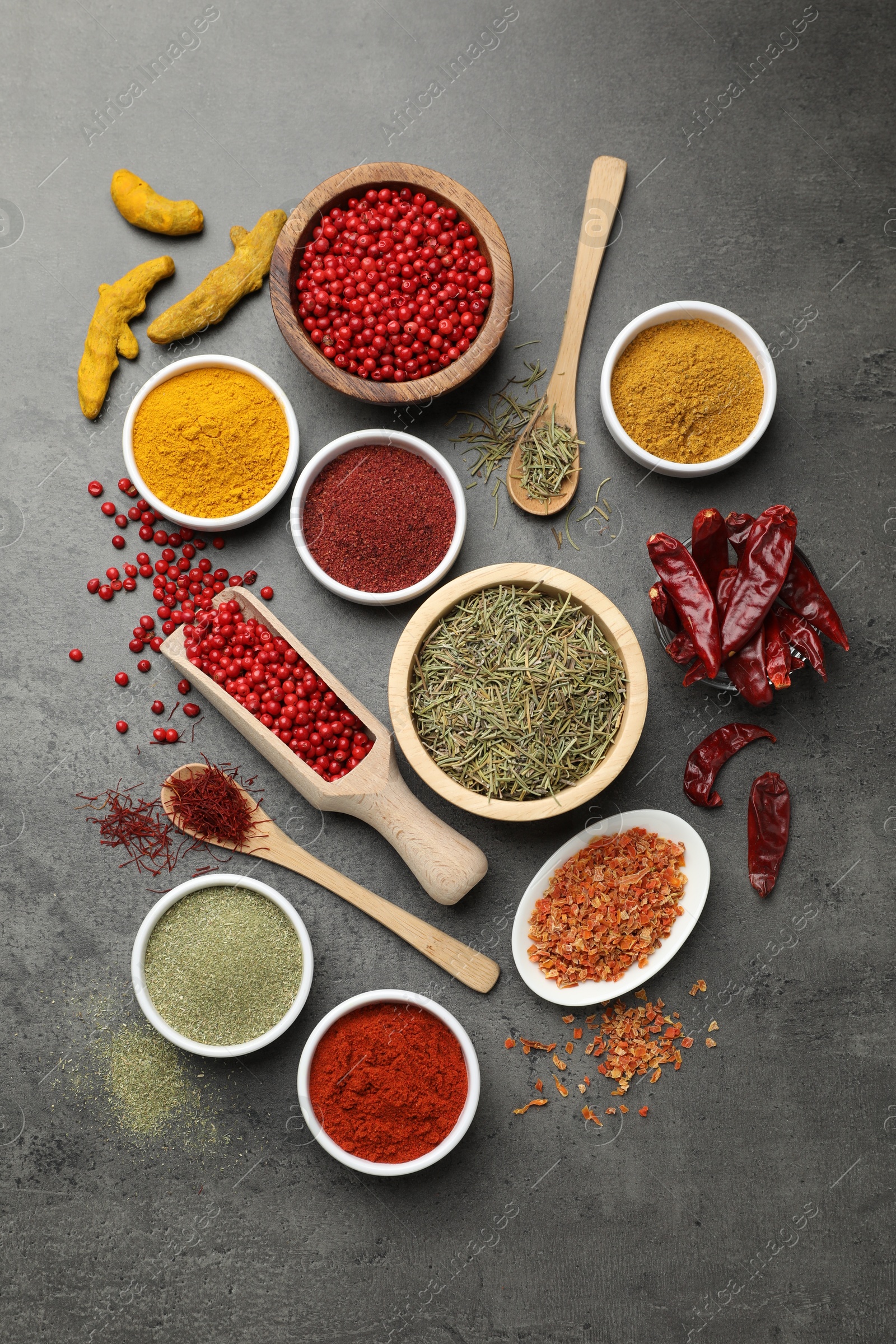 Photo of Different aromatic spices on grey table, flat lay