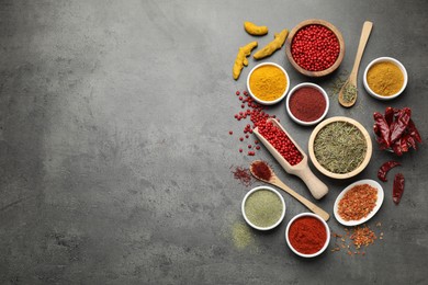 Photo of Different aromatic spices on grey table, flat lay. Space for text