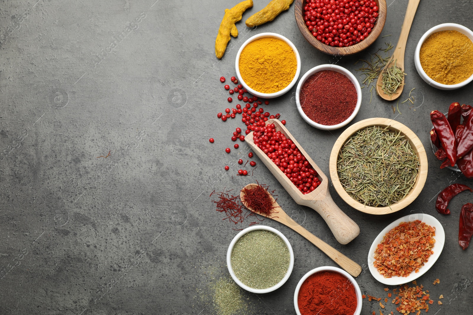 Photo of Different aromatic spices on grey table, flat lay. Space for text