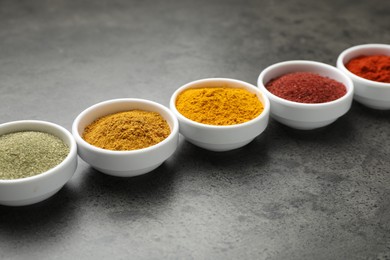 Photo of Different aromatic spices on grey table, closeup