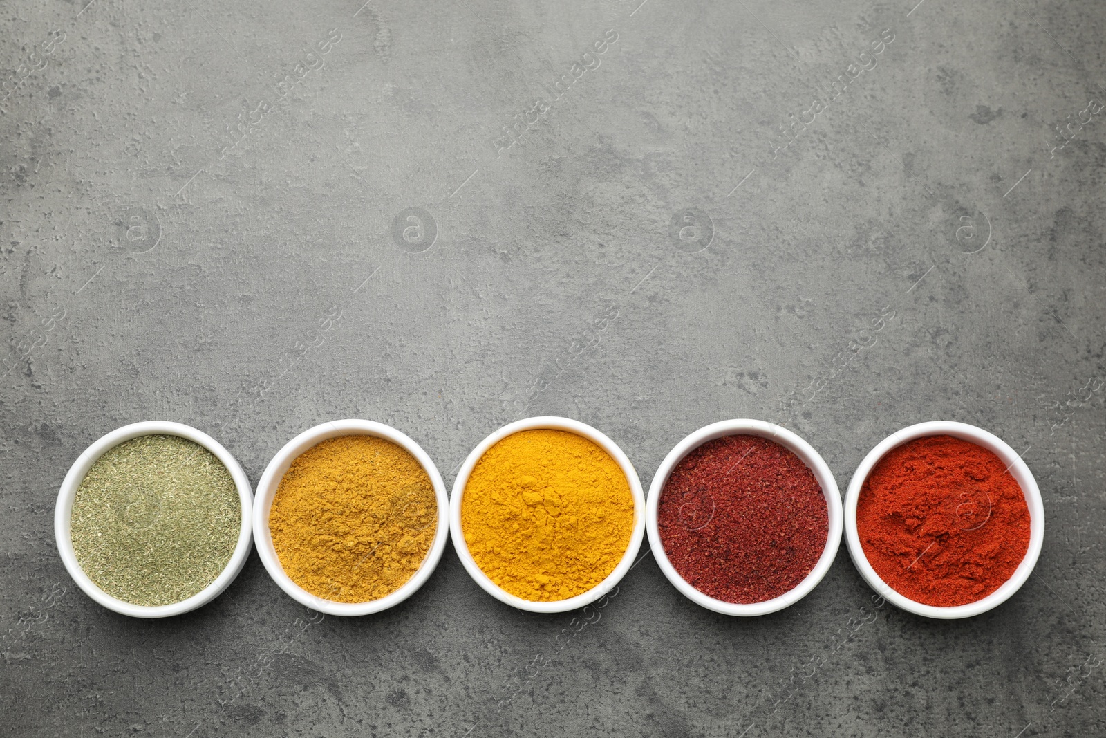 Photo of Different aromatic spices on grey table, top view. Space for text