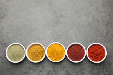 Photo of Different aromatic spices on grey table, top view. Space for text