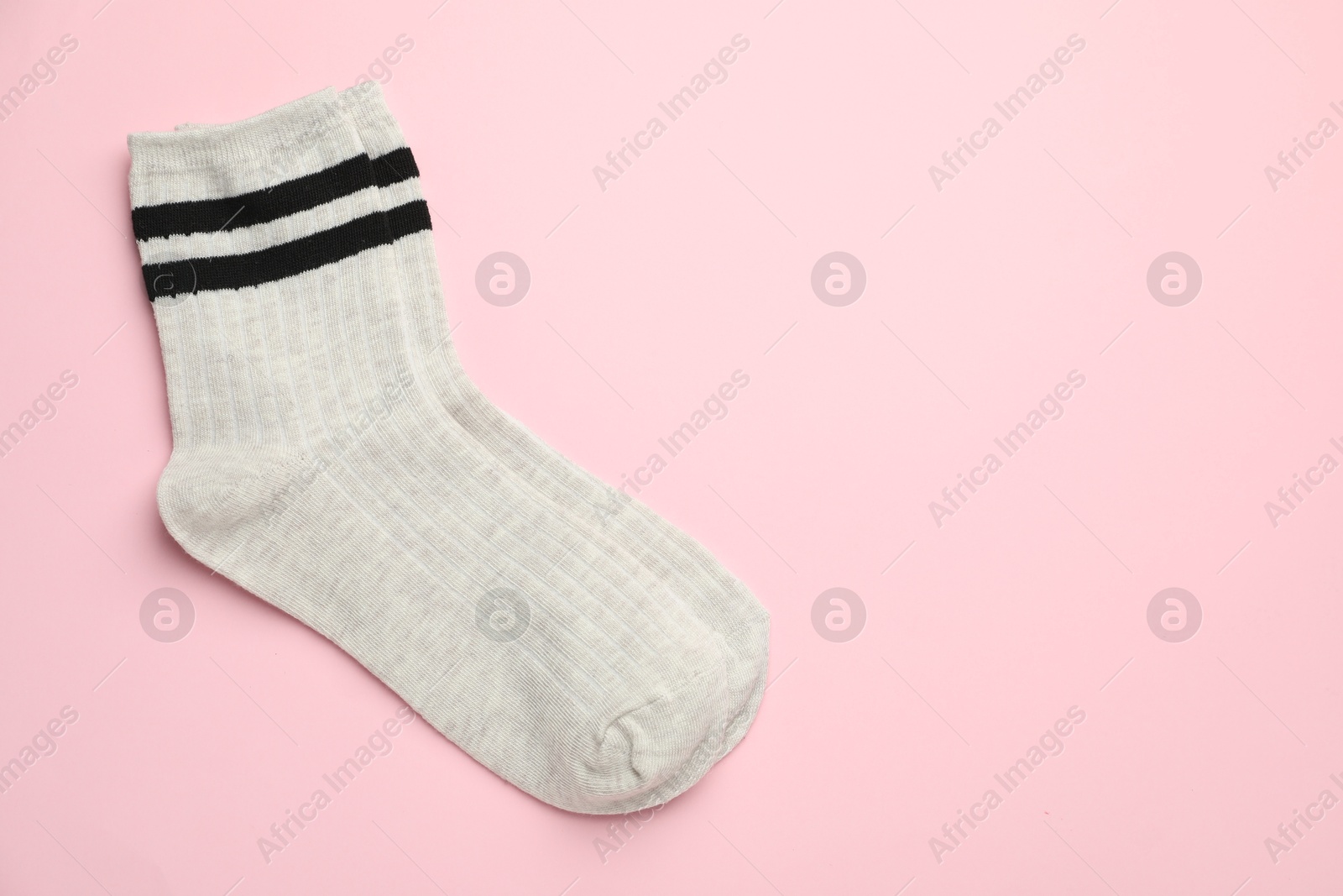 Photo of Pair of soft comfortable socks on light pink background, top view. Space for text