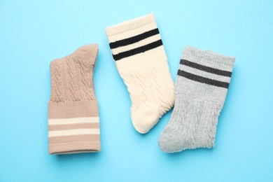 Photo of Different comfortable socks on light blue background, flat lay