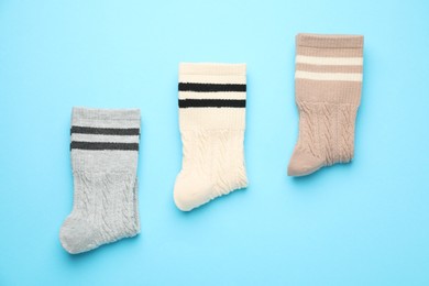 Photo of Different comfortable socks on light blue background, flat lay