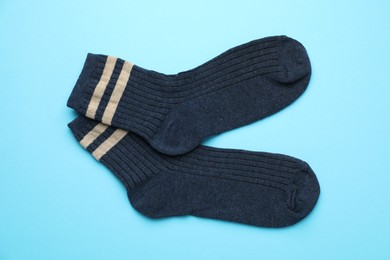 Photo of Pair of soft comfortable socks on light blue background, top view