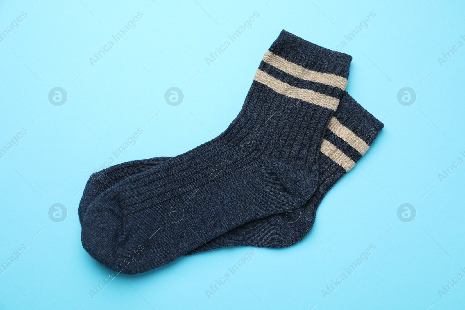 Photo of Pair of soft comfortable socks on light blue background, top view