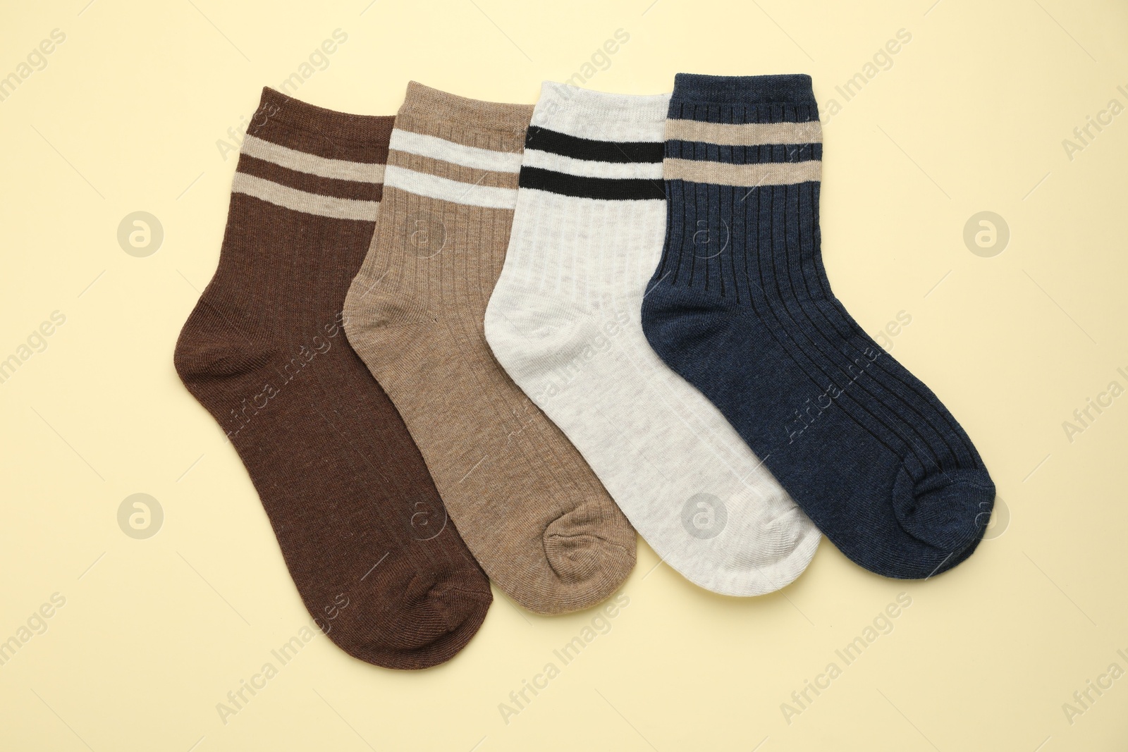 Photo of Different comfortable socks on beige background, flat lay