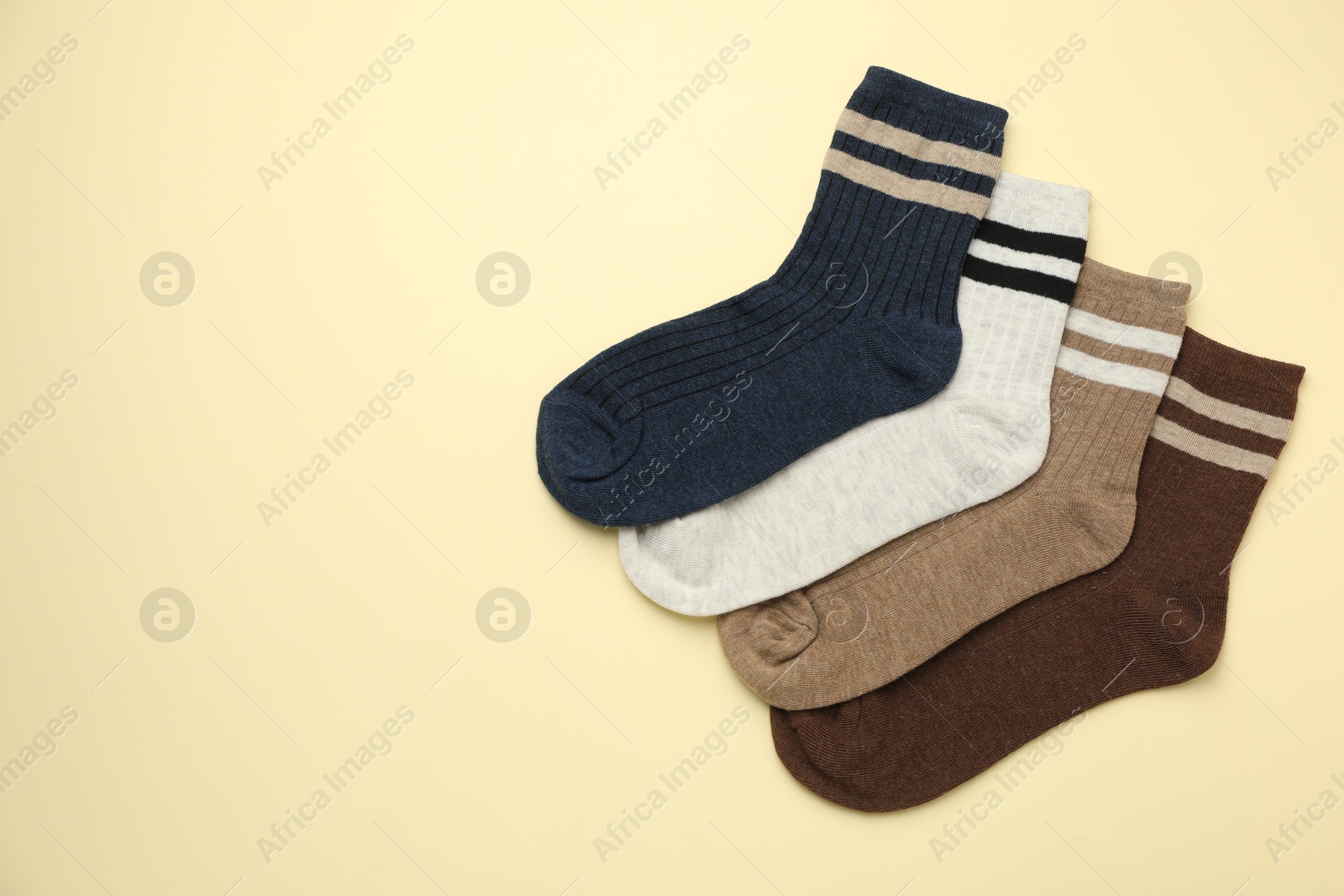 Photo of Different comfortable socks on beige background, flat lay. Space for text