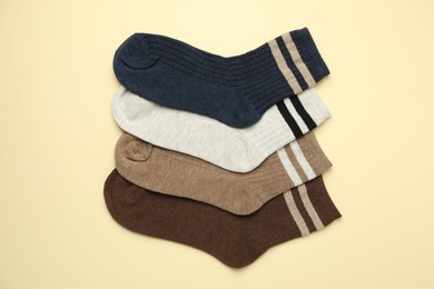 Photo of Different comfortable socks on beige background, flat lay