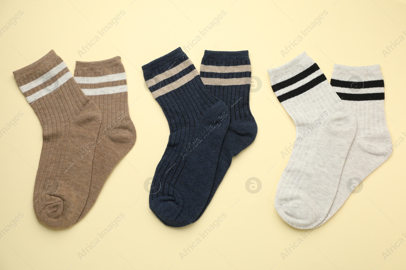 Photo of Different comfortable socks on beige background, flat lay