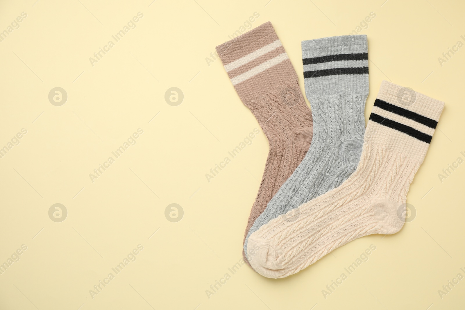 Photo of Different comfortable socks on beige background, flat lay. Space for text