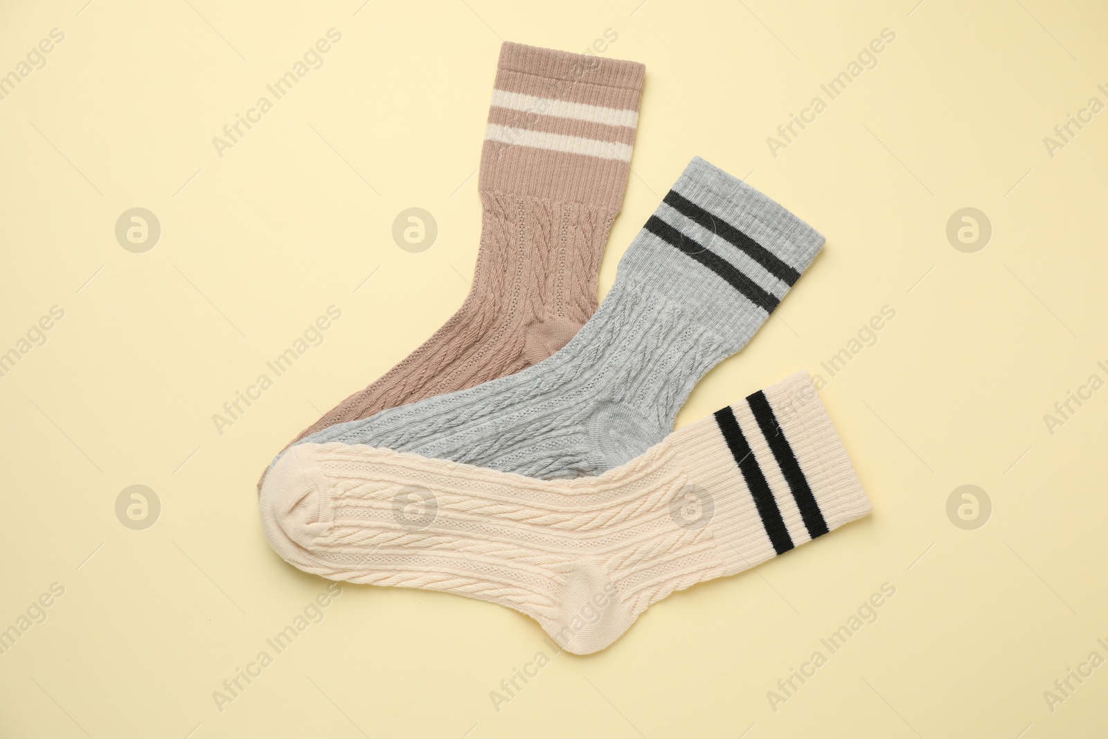 Photo of Different comfortable socks on beige background, flat lay