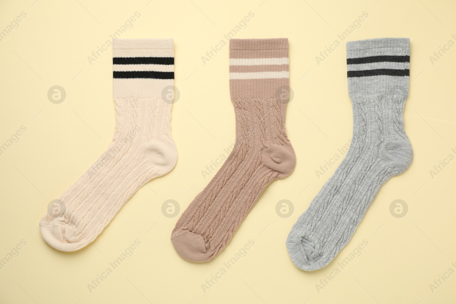 Photo of Different comfortable socks on beige background, flat lay