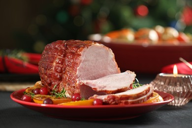 Tasty baked ham served on black wooden table, closeup