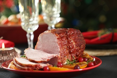 Photo of Tasty baked ham served on black wooden table, closeup