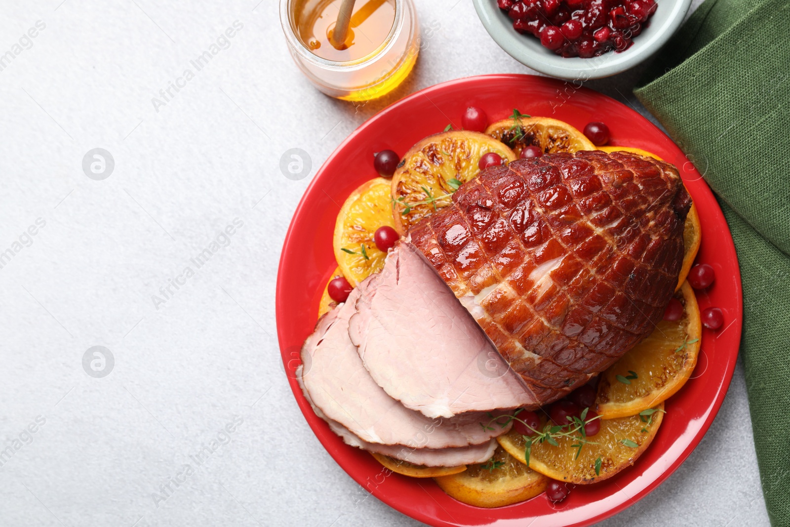 Photo of Tasty baked ham served on white table, flat lay. Space for text