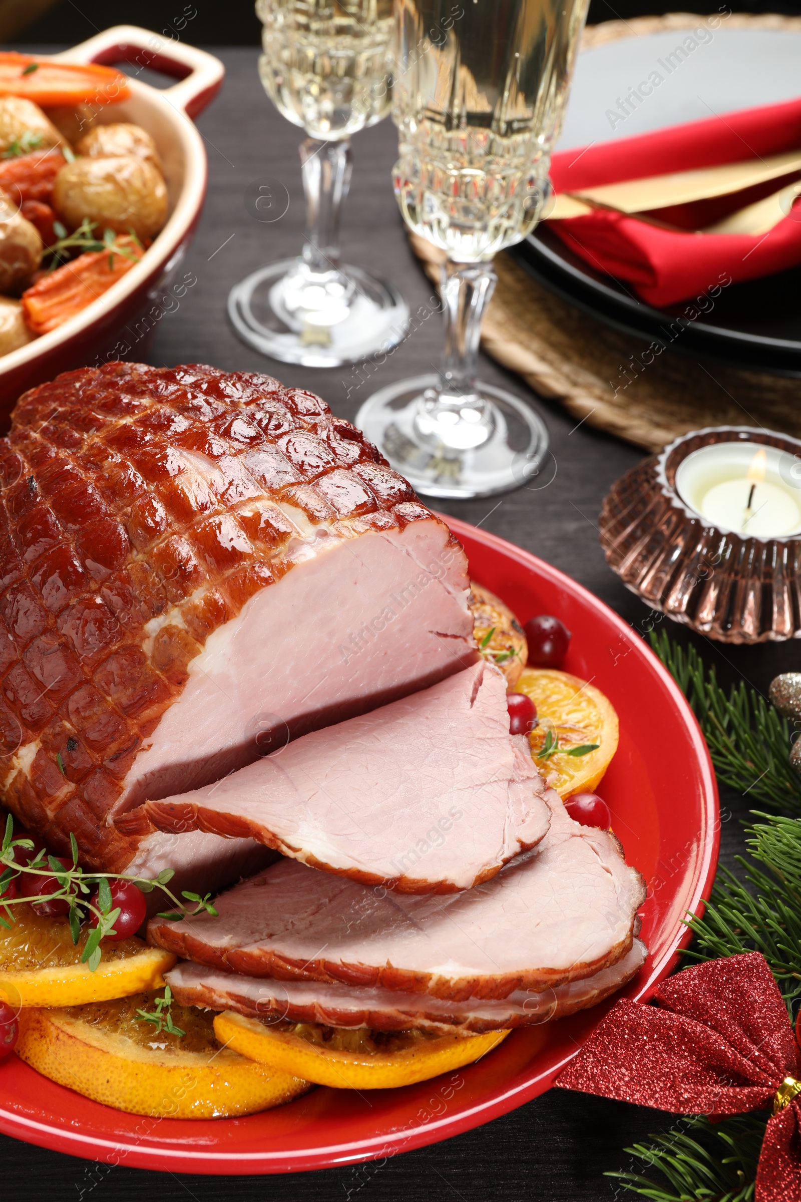 Photo of Tasty baked ham served on black wooden table, closeup