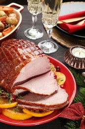 Photo of Tasty baked ham served on black wooden table, closeup