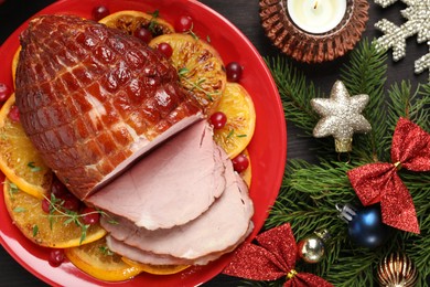 Photo of Tasty baked ham served on black wooden table, flat lay