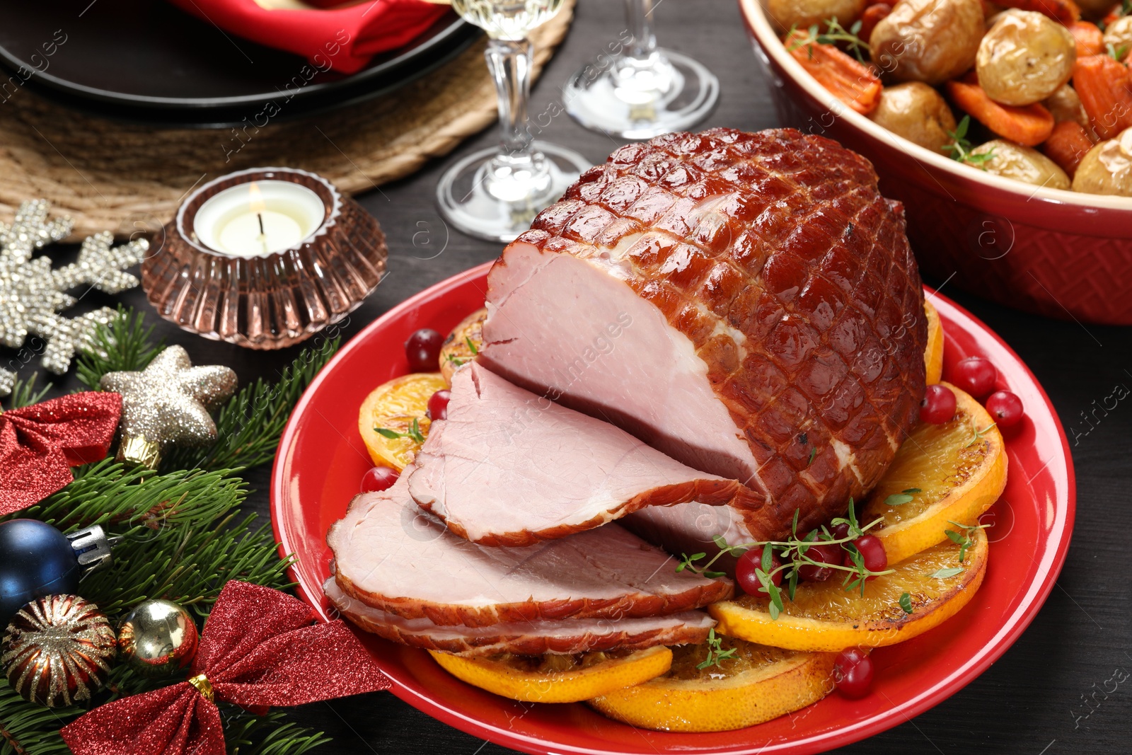 Photo of Tasty baked ham served on black wooden table