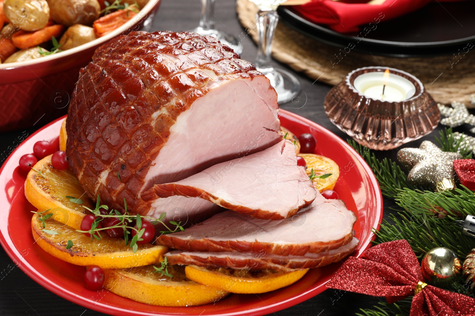 Photo of Tasty baked ham served on black wooden table, closeup