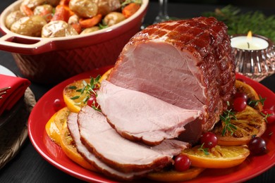 Tasty baked ham served on black wooden table, closeup