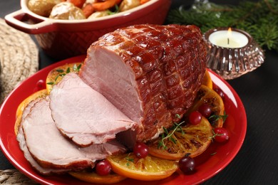 Photo of Tasty baked ham served on black wooden table, closeup