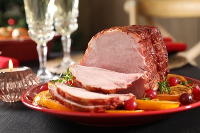 Tasty baked ham served on black wooden table, closeup