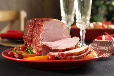 Tasty baked ham served on black wooden table, closeup