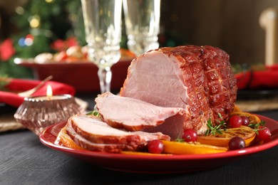 Photo of Tasty baked ham served on black wooden table, closeup