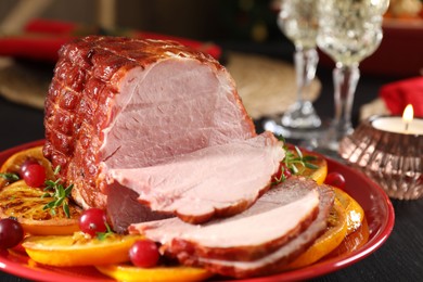 Tasty baked ham served on black wooden table, closeup