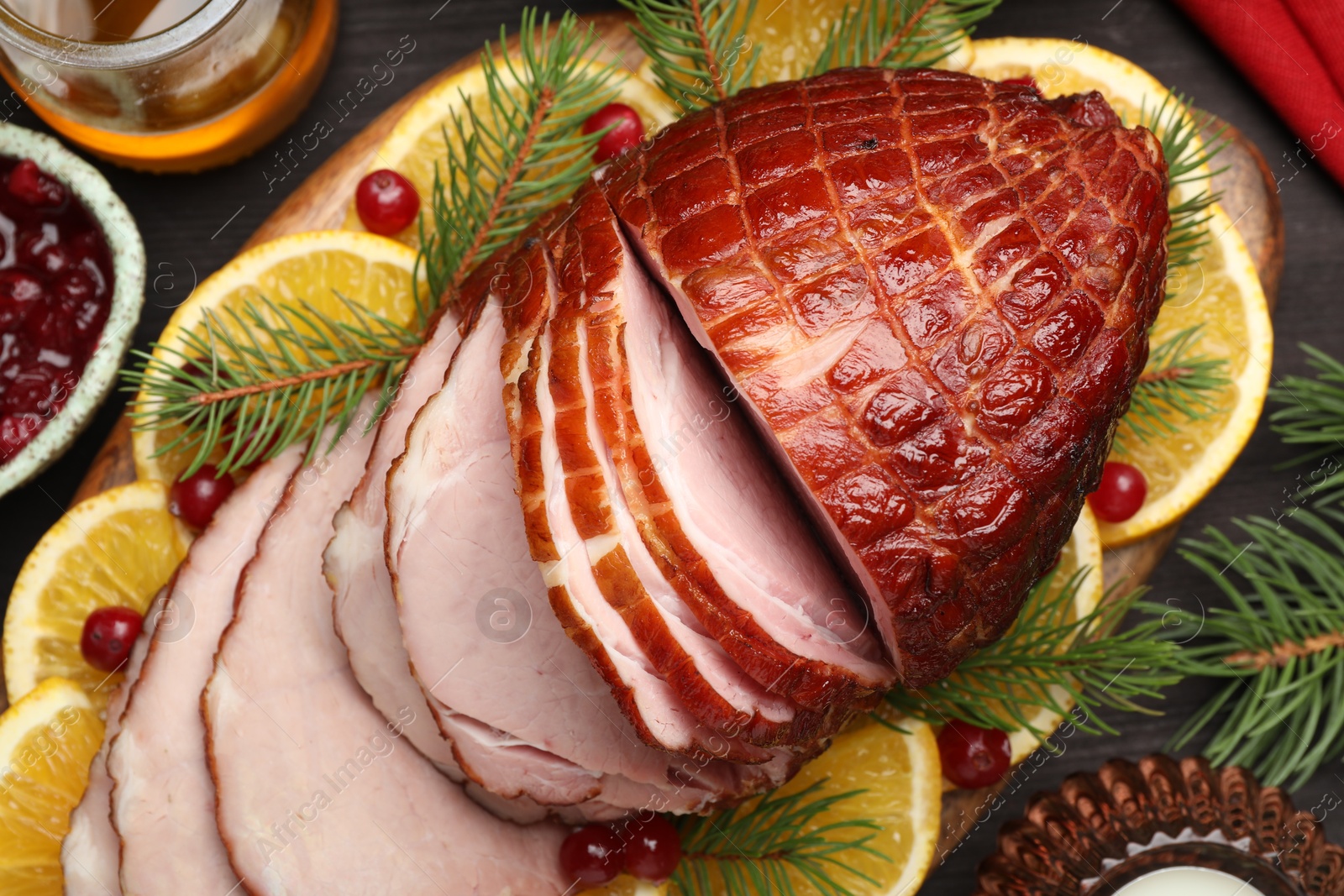 Photo of Tasty baked ham served on black wooden table, flat lay