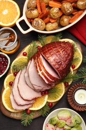 Tasty baked ham served on black wooden table, flat lay