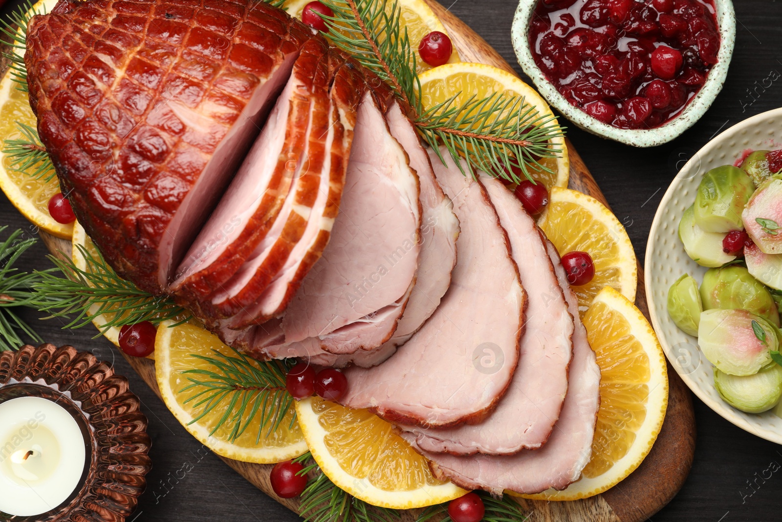 Photo of Tasty baked ham served on black wooden table, flat lay