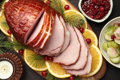 Photo of Tasty baked ham served on black wooden table, flat lay