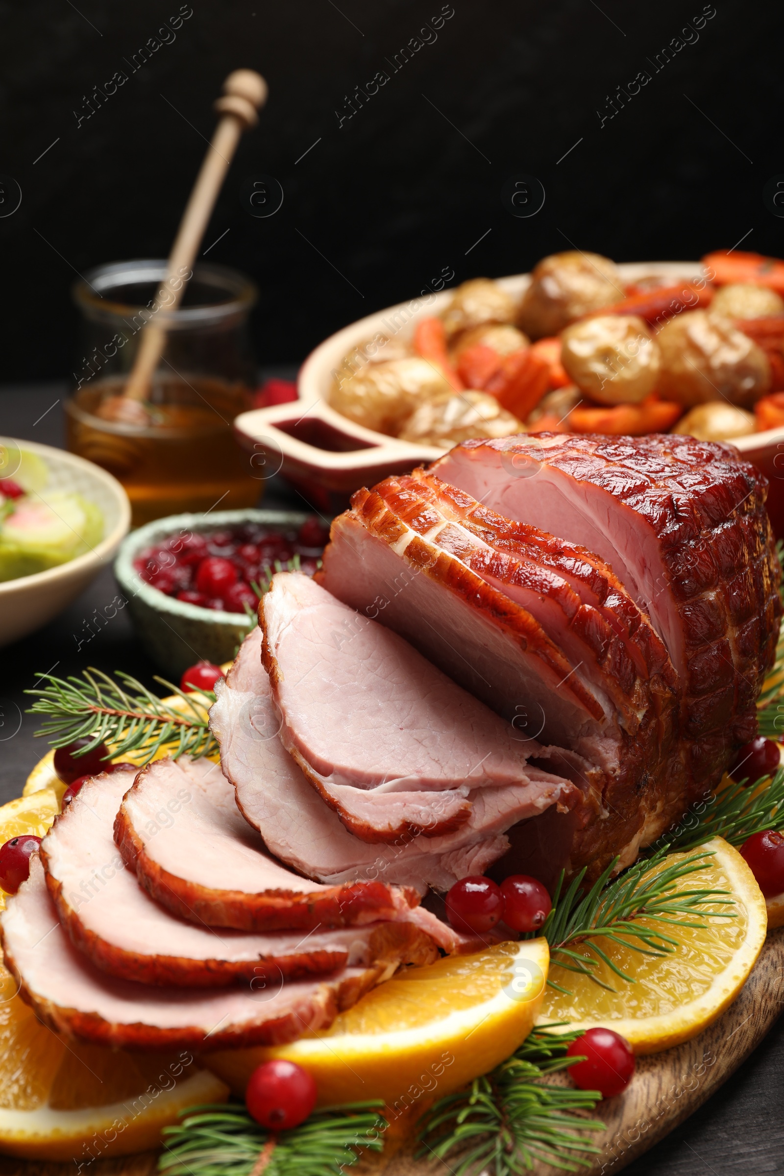 Photo of Tasty baked ham served on black wooden table, closeup