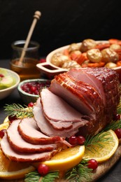 Tasty baked ham served on black wooden table, closeup