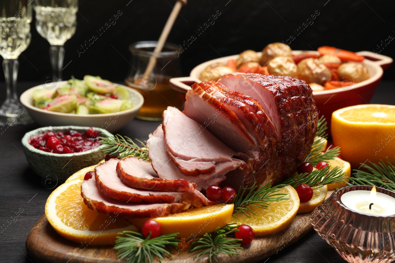 Photo of Tasty baked ham served on black wooden table